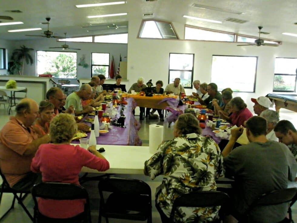 Residents enjoying a large fall festival meal together inside Camelot RV Park’s community hall