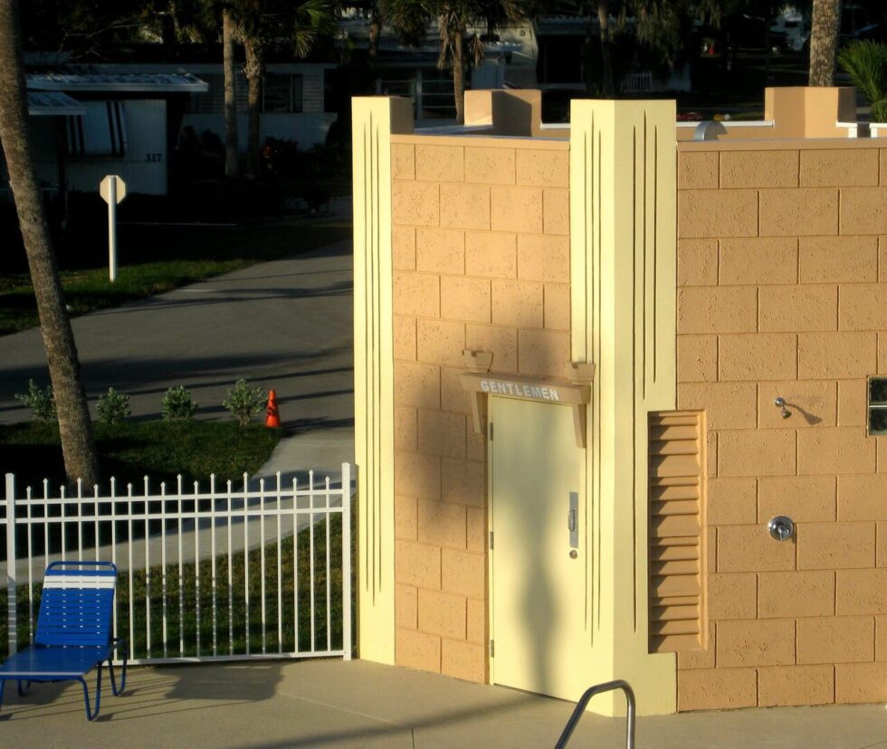 Exterior view of the men’s bath and shower building located next to the pool at Camelot RV Park