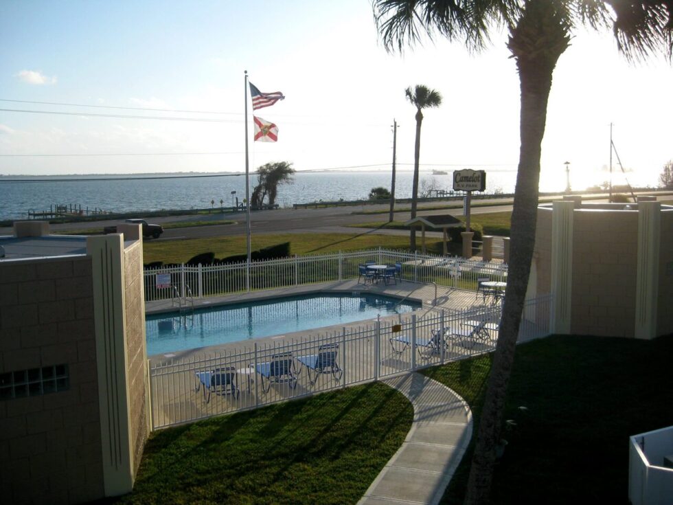 Scenic view of Camelot RV Park’s pool area with Indian River backdrop during sunset