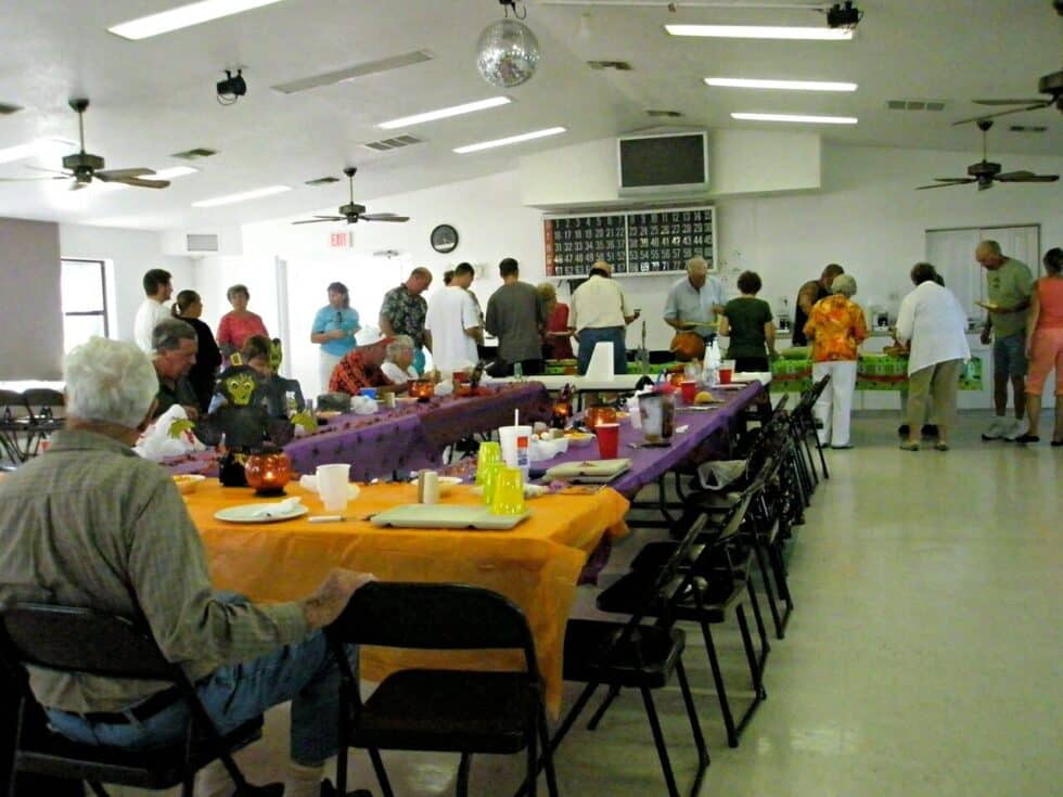 Residents enjoying a large buffet-style potluck dinner inside the recreation hall