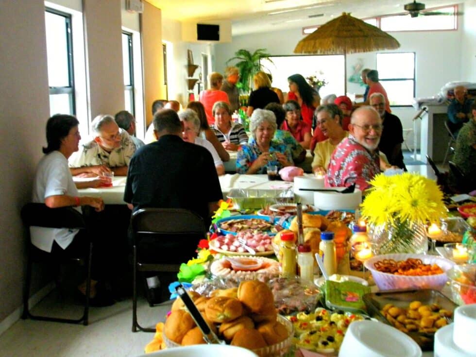 Residents at Camelot RV Park enjoying a shared meal and social gathering inside the recreation hall